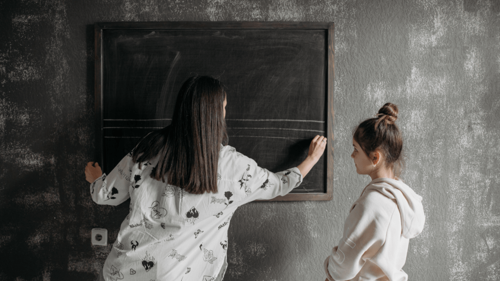 A person is writing on a blackboard