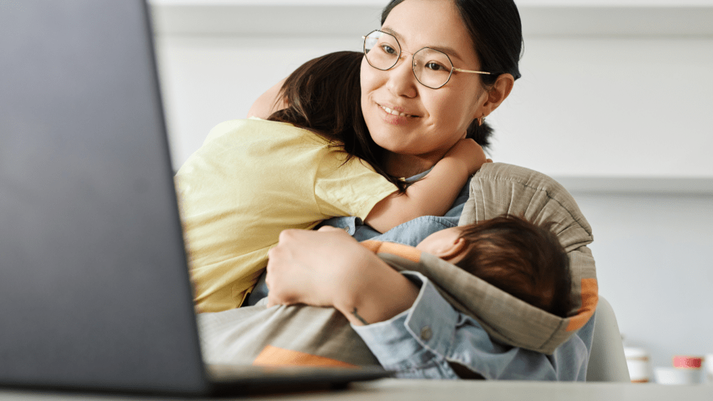 A person working on a laptop in a living room with children in the background