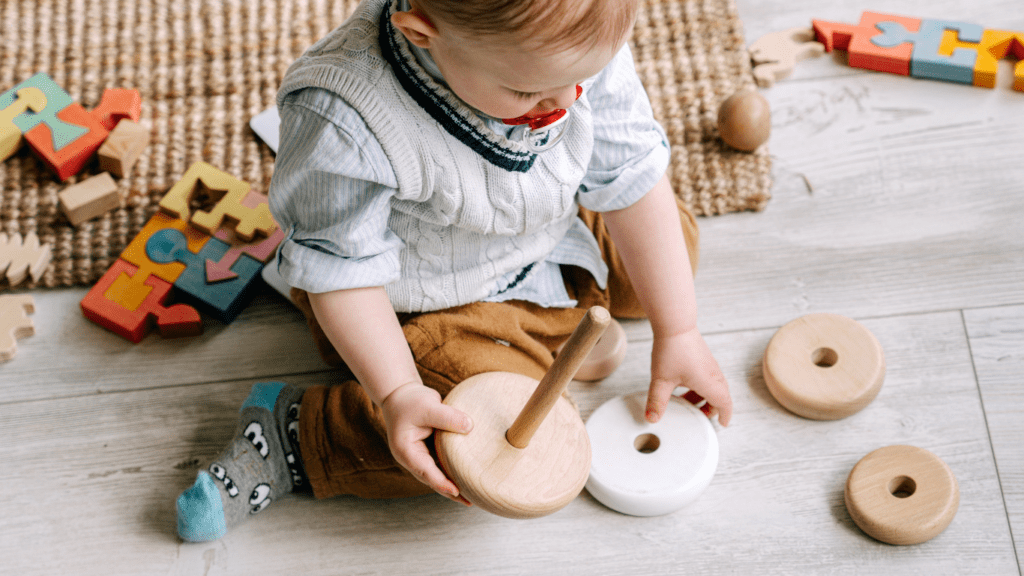 a toddler playing with wooden toys on the floor