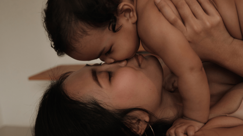 a person kissing a baby