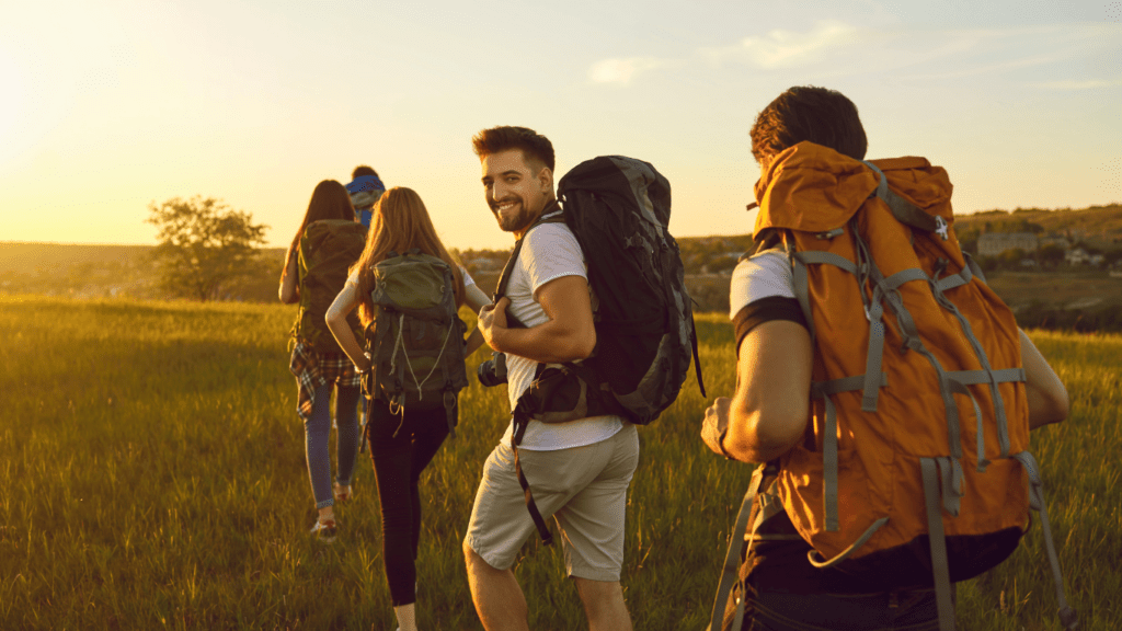 a group of people with backpacks hiking up a mountain