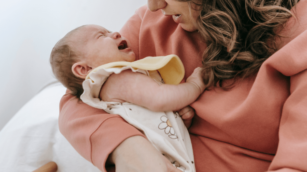 a person is holding a baby in a hospital bed