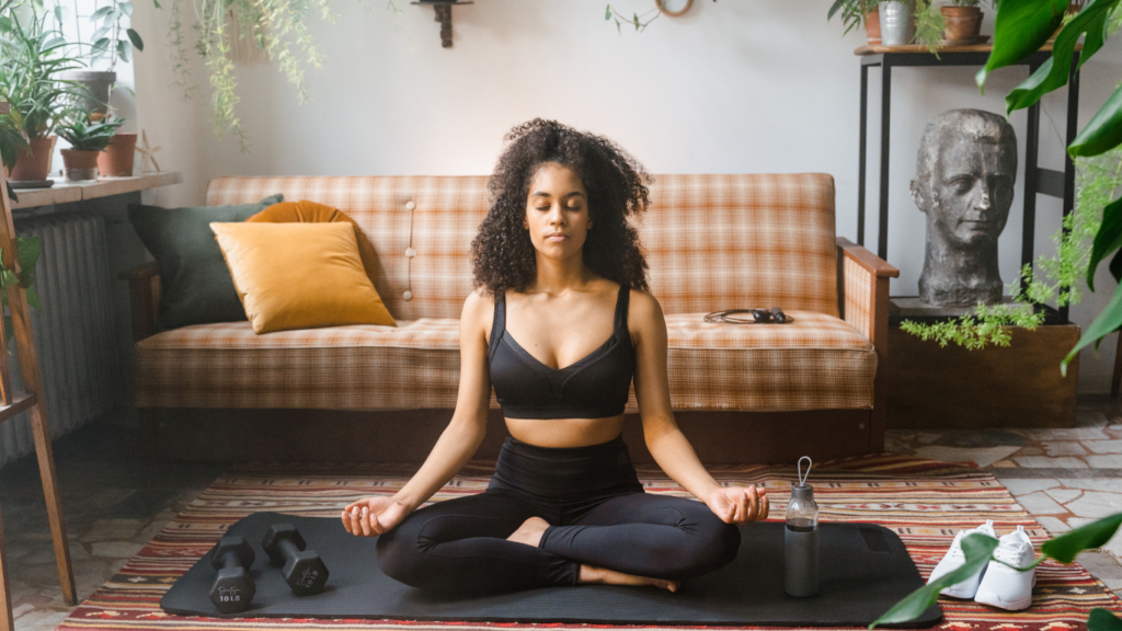 a person is sitting on a yoga mat in their living room