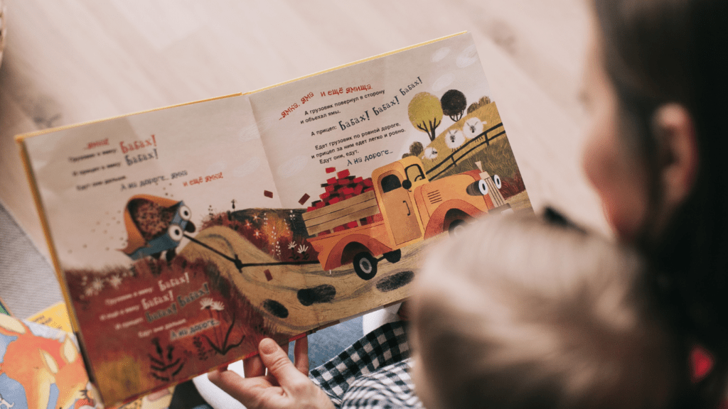 a person reads to their children while sitting on a couch