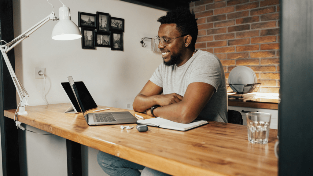 a person sitting at the table in front of a laptop