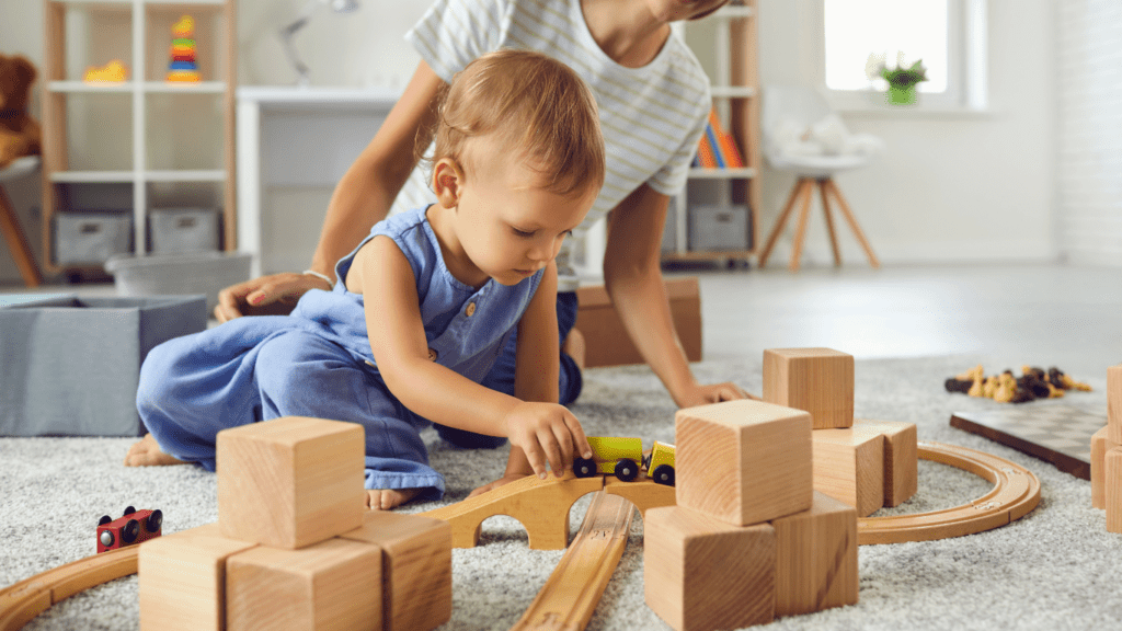 a toddler playing with wooden toys on the floor