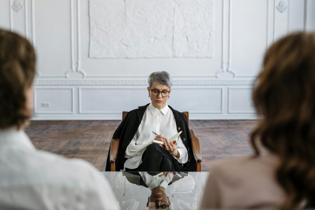 A therapist conducts a focused session with a couple in a stylish office.